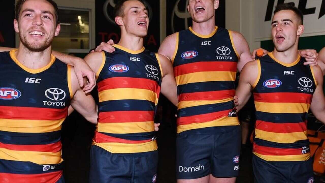 Adelaide Crows players sing the team song after their win