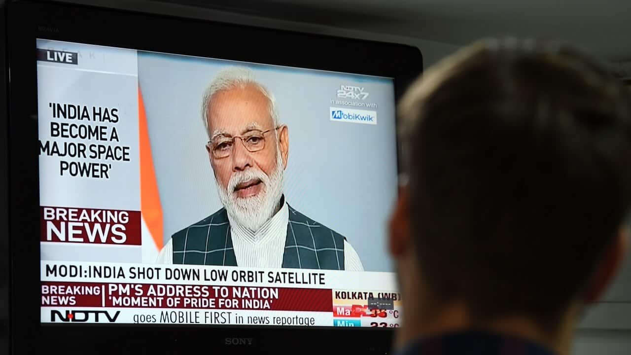 A man watches Indian Prime Minister Narendra Modi's address to the nation.