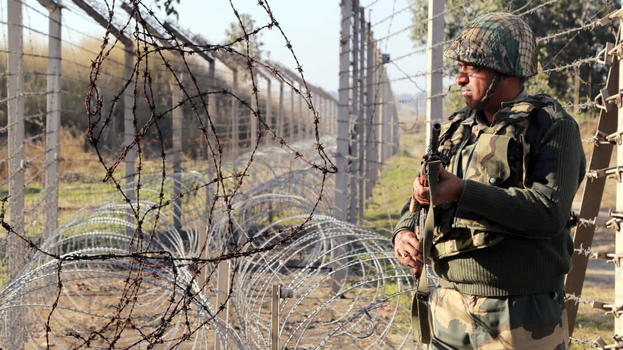 Border Security Force (BSF) soldier stand guard near India-Pakistan border fencing