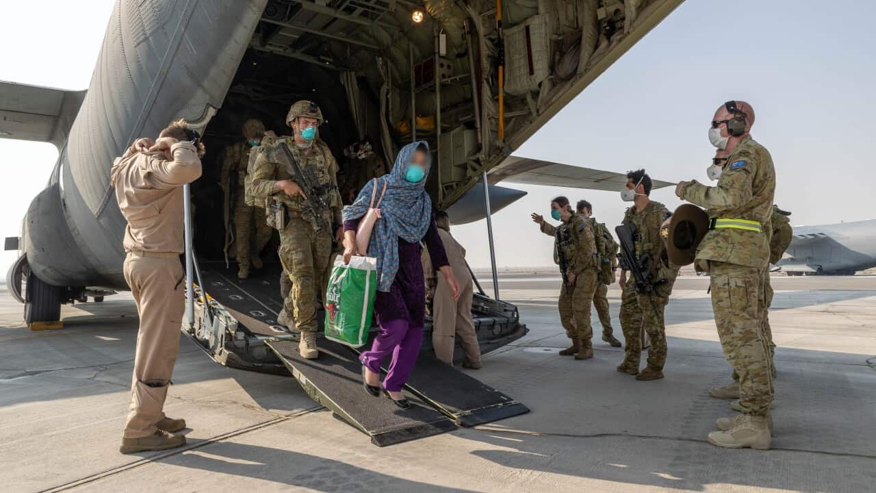 A supplied image from Friday, August 27, 2021, shows Afghanistan evacuees and soldiers disembarking at a base
