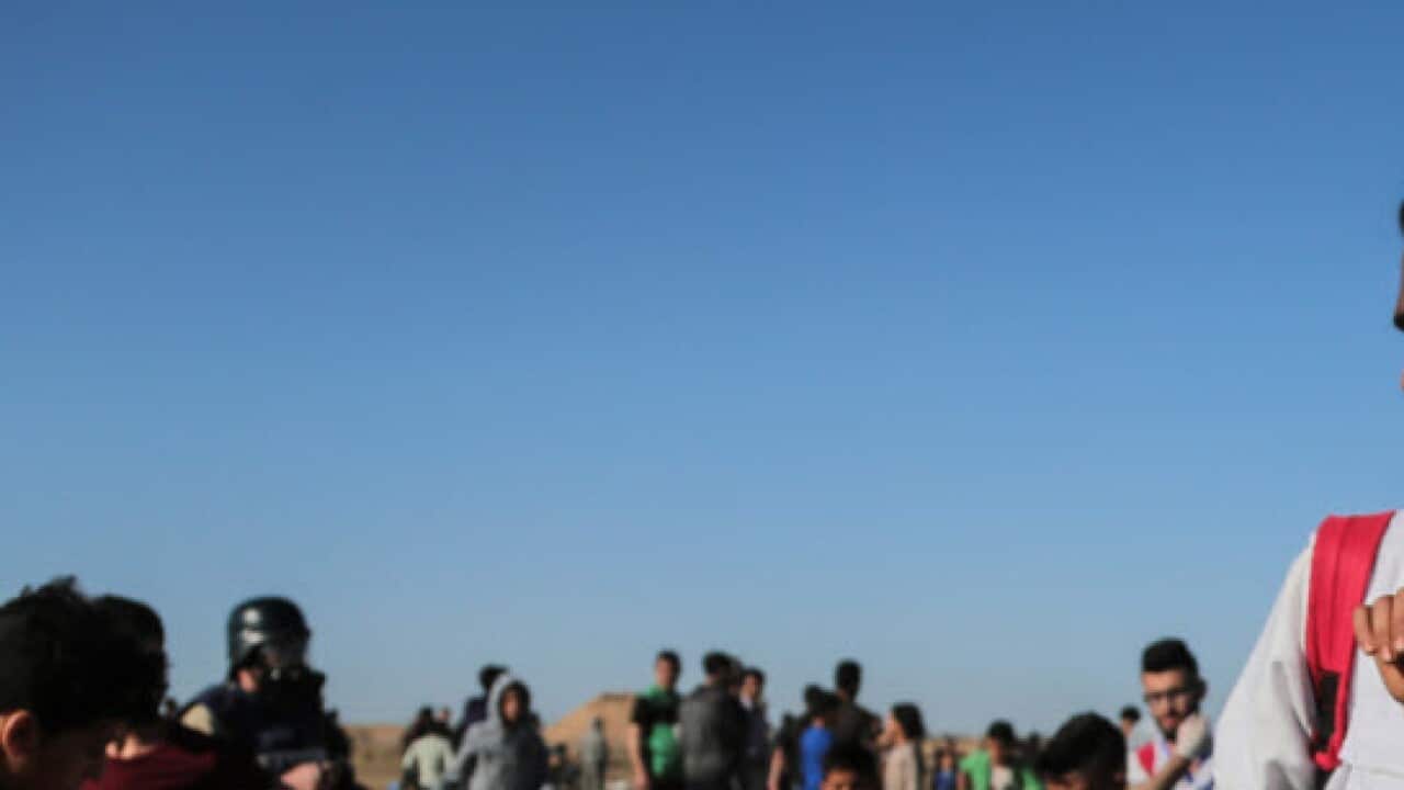 Palestinian medic seen carrying an injured kid during the clashes (AAP)
