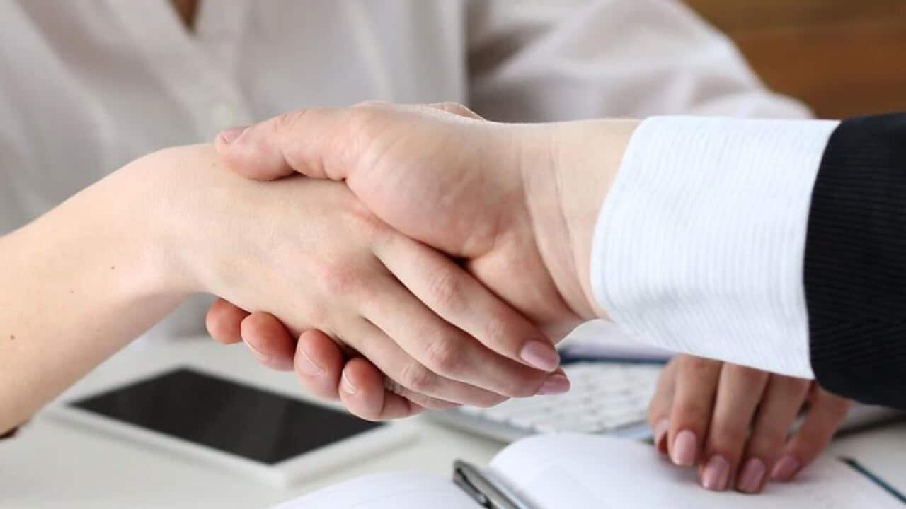 Businessman and woman shake hands.