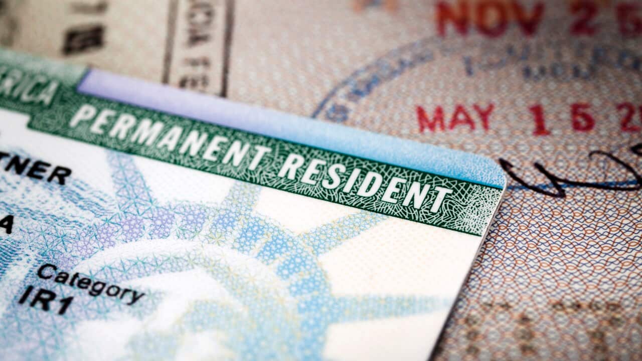 A Green Card lying on an open passport, close-up, full frame