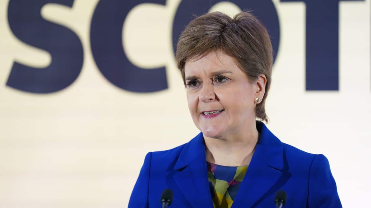 Nicola Sturgeon standing in front of two microphones