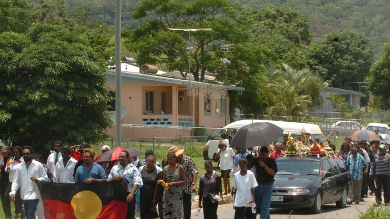 Palm Islanders walk during the funeral for Cameron Doomadgee.