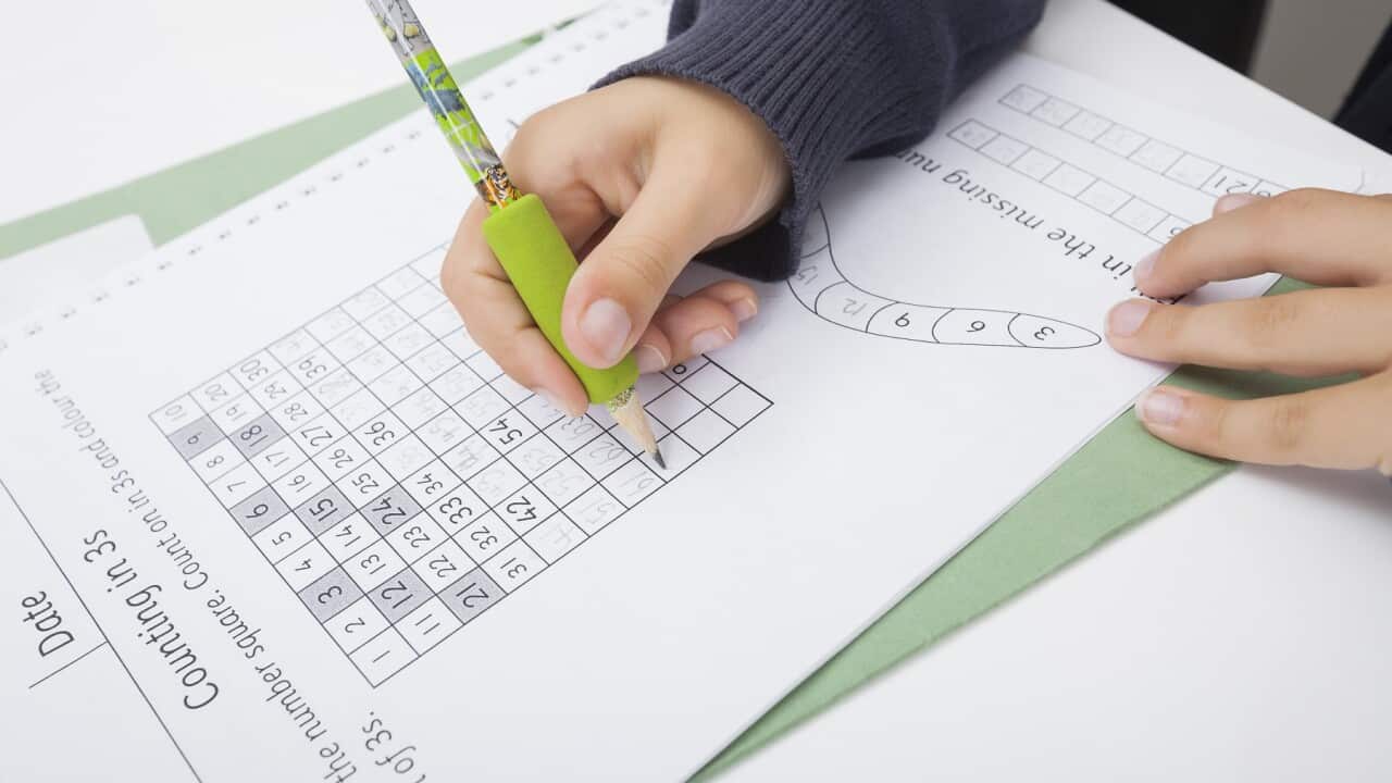 A student writes on a worksheet
