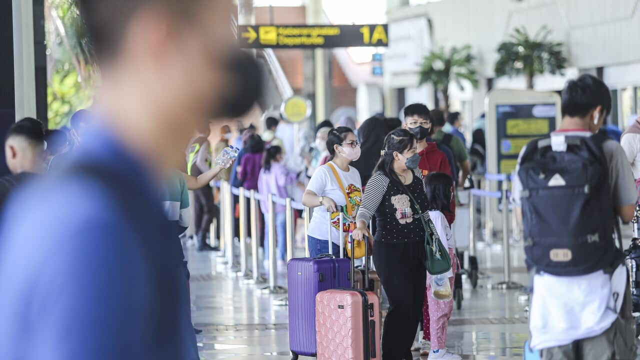 People in the departure hall of an airport.