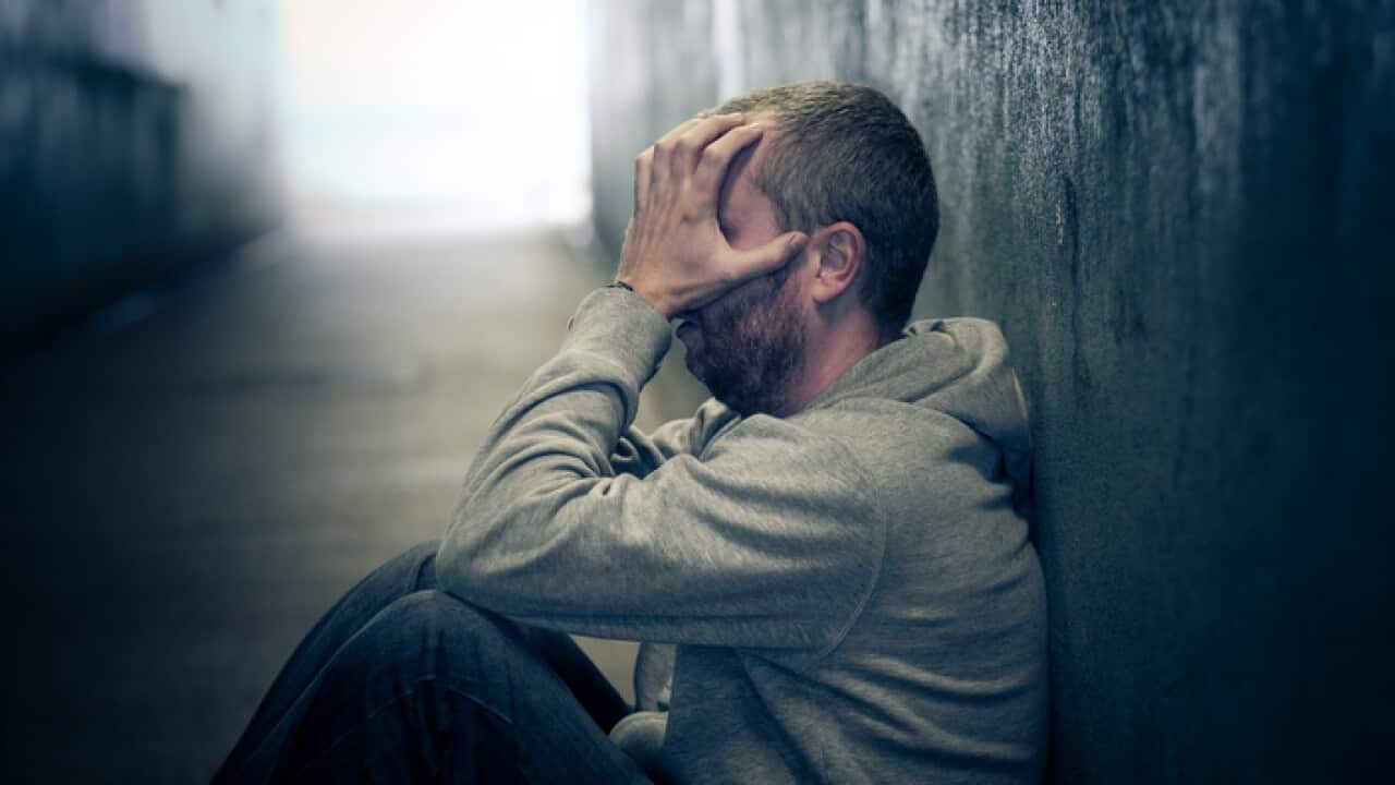 Young homeless caucasian male sitting in dark subway tunnel