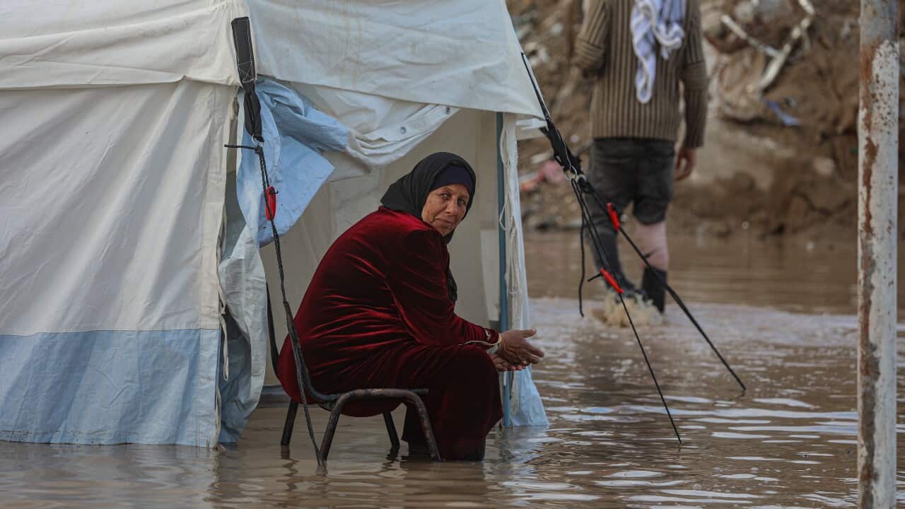 An internally displaced Palestinian woman sits outside her flooded tent following heavy downpours in the Al Zaitun neighbourhood in the east of Gaza City, Gaza Strip, 25 November 2025.