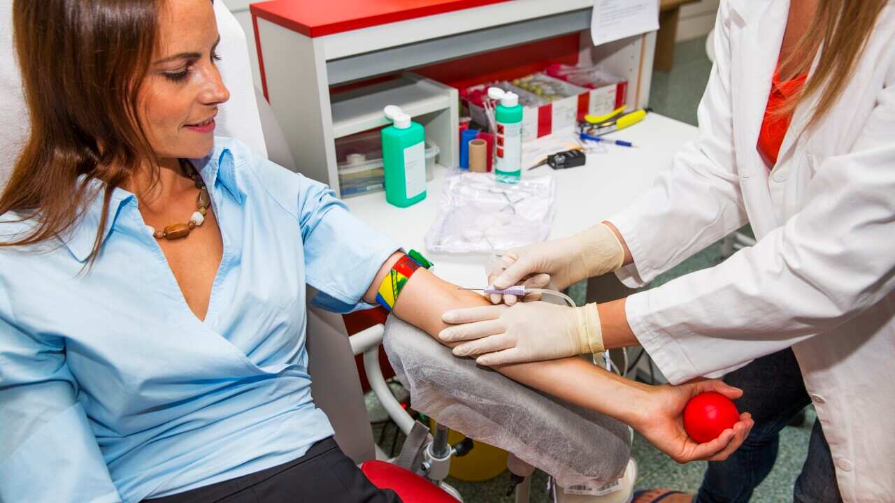 A woman holding out her arm to have blood taken