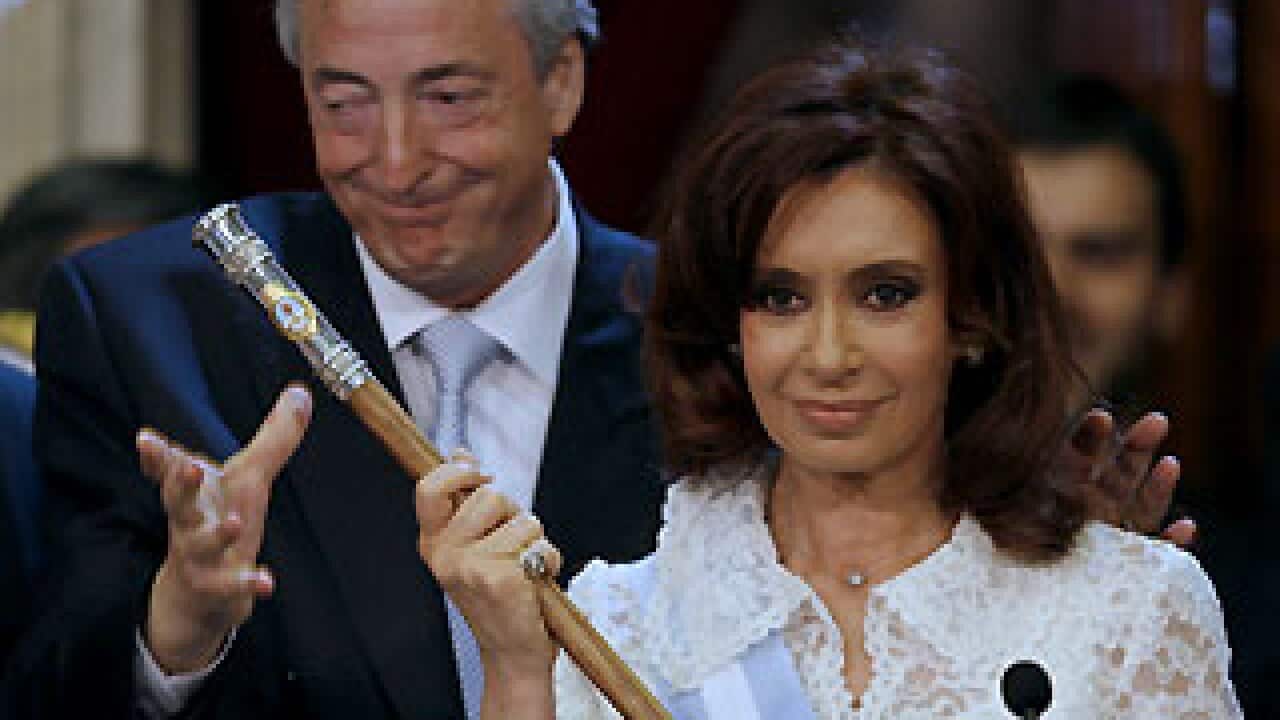Former Argentinian president Nestor Kirchner hands over the staff of office to his wife, the new president Cristina Fernandez