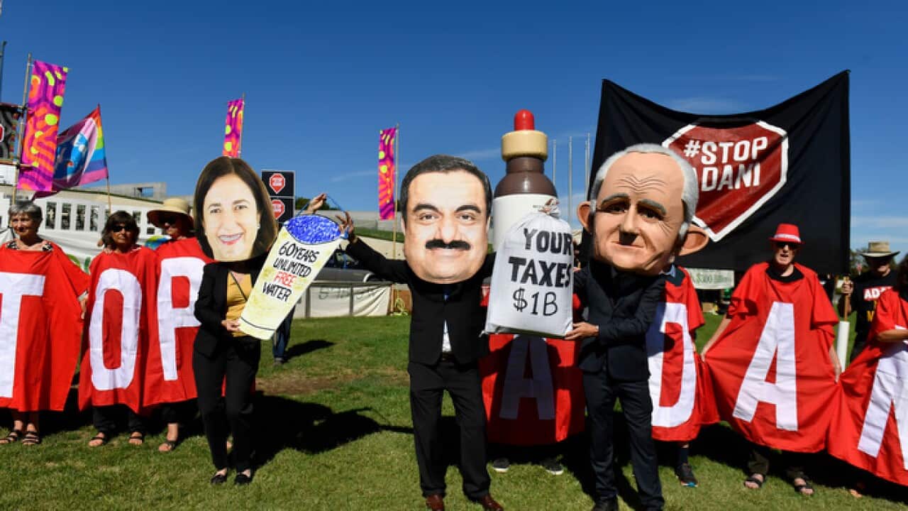 Protesters hold signs and banners at a Stop Adani Mine rally on the lawns of Parliament House in Canberra, Monday, February 5, 2018. (AAP Image/Mick Tsikas) NO ARCHIVING