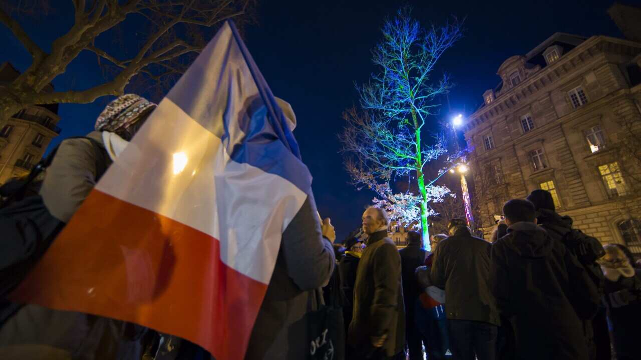 Parisians gather in front of the newly illuminated oak tree on Place de la Republique after a commemoration ceremony to mark the one-year anniversary of the unity march which had gathered over a million people in the wake of the Charlie Hebdo and Hypercac