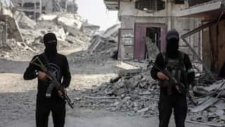 Two Hamas fighters wearing black clothing and balaclavas holding rifles