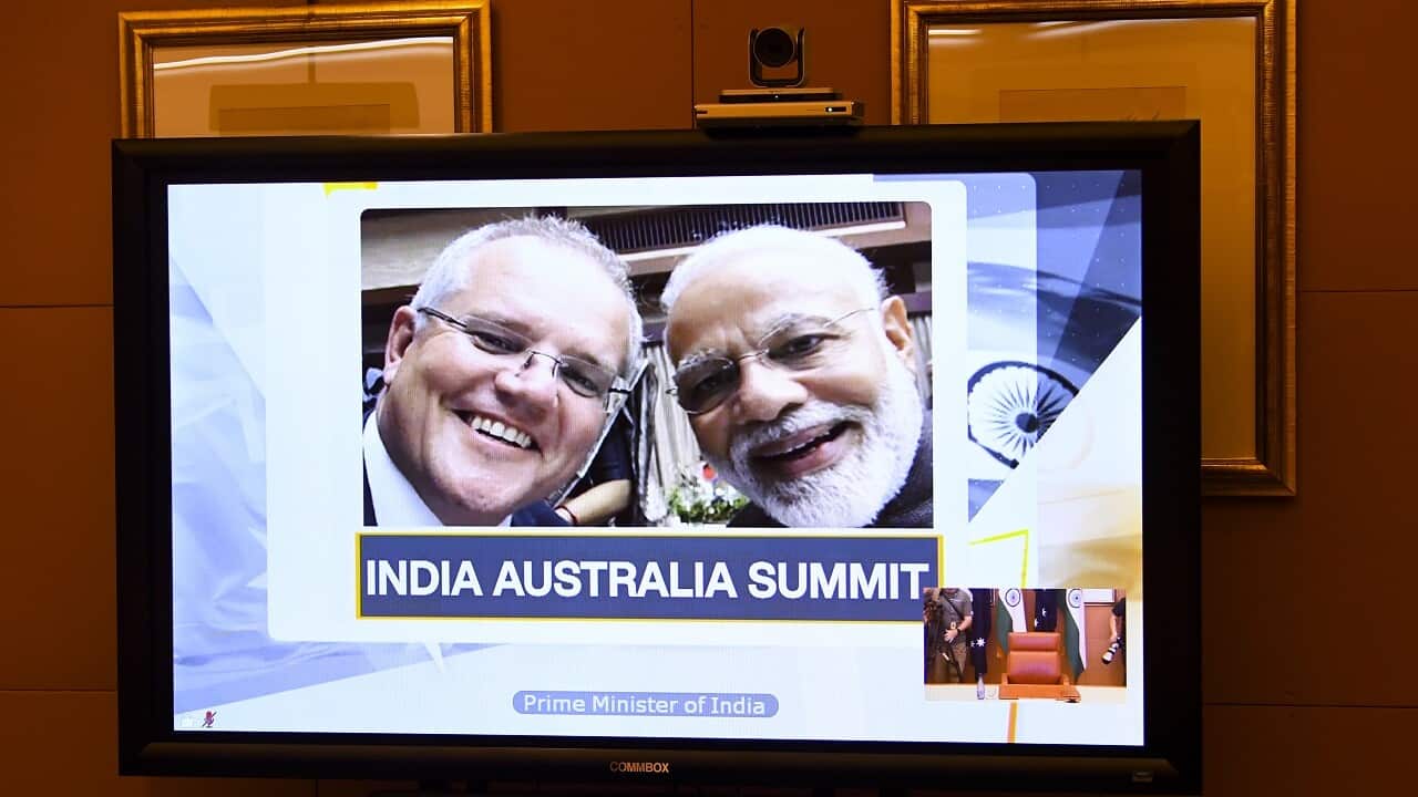 A picture of Australian Prime Minister Scott Morrison (left) and Indian Prime Minister Narendra Modi is displayed on a conference screen
