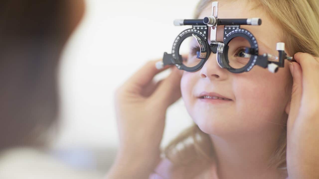 Eye doctor examining girl's vision