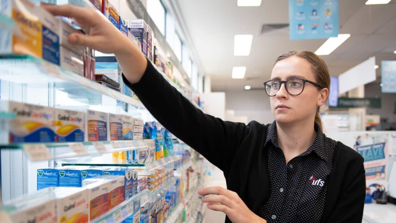 A pharmacist reaches for medicine at a shop in Coburg, Melbourne