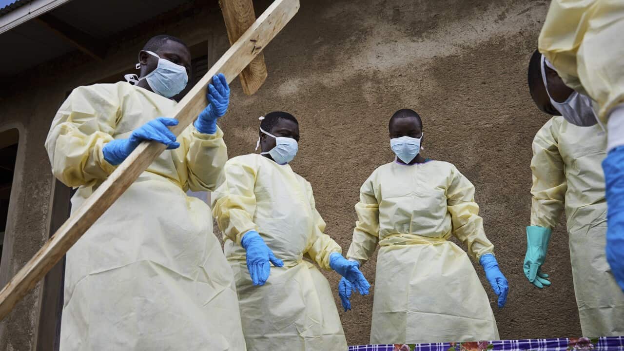 Health workers take part in the funeral of Kahumbu Ngalyakuthi, who got infected after sharing a hospital room with a patient infected with Ebola in DRC