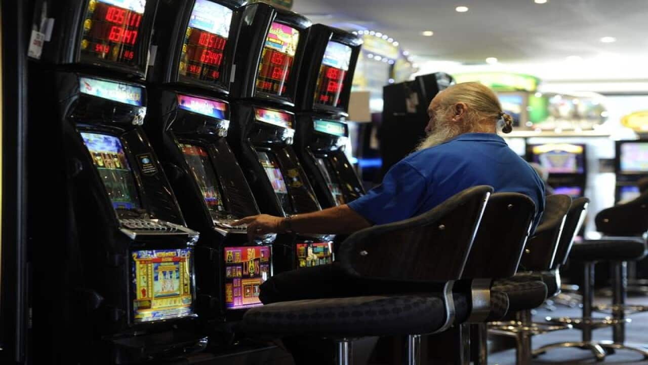 A file image of a man playing poker machines at a club