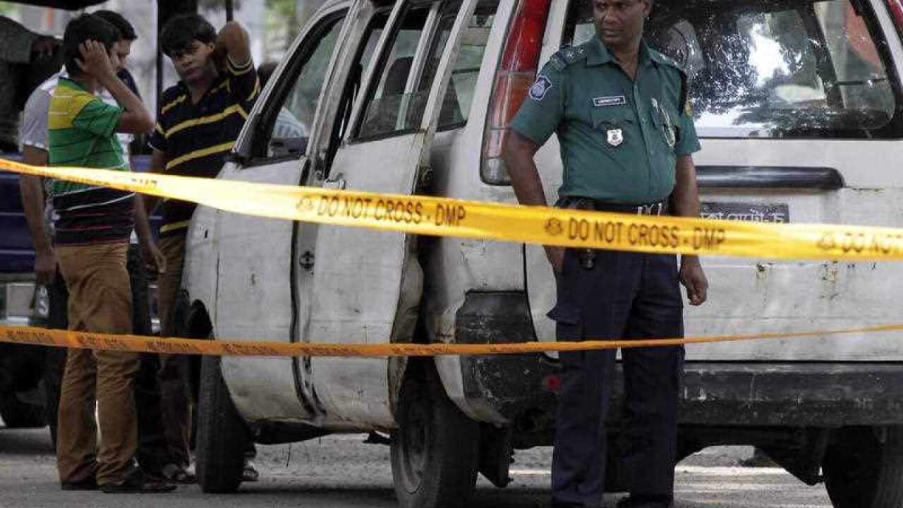 Members of Bangladeshi police and detective branch stand by the site where Italian citizen Cesare Tavella was gunned down by unidentified assailants in Dhaka, Bangladesh, Tuesday, Sept. 29, 2015.