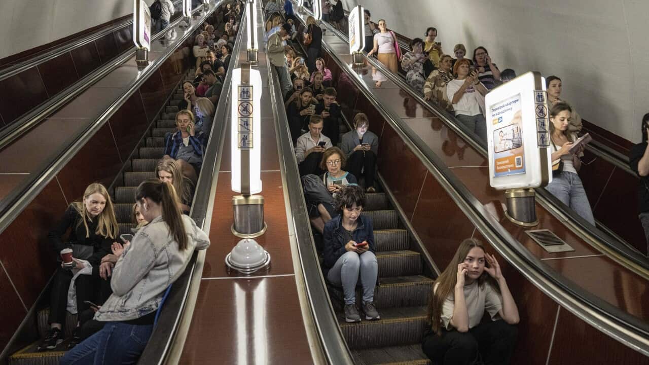People take cover at a metro station during a Russian rocket attack in Kyiv
