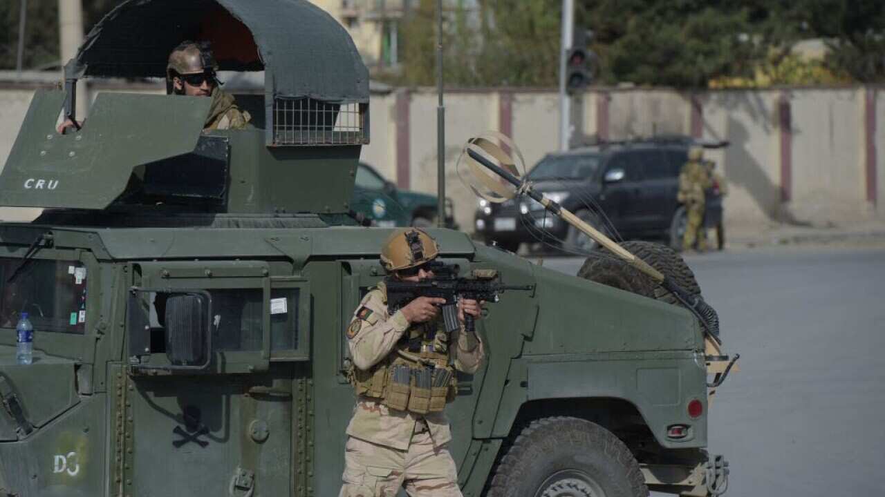 Afghan security personnel stand guard along a road in Kabul on November 7, 2017.