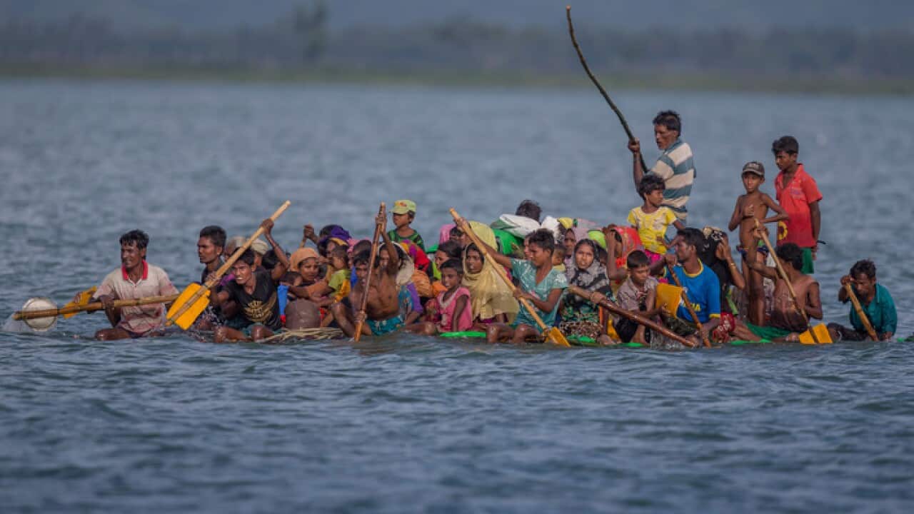 Rohingya refugees flee on a makeshift raft in 2017