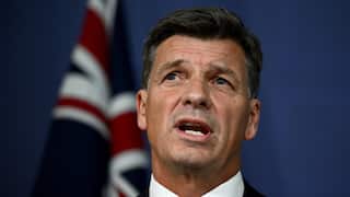 A man with Australian flag in the background.