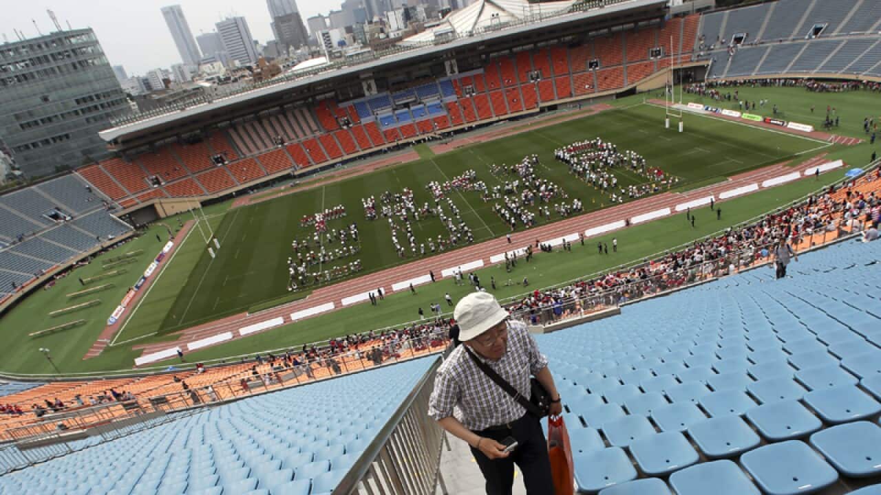 Volunteers form “Japan 2020" at the National Stadium in Tokyo