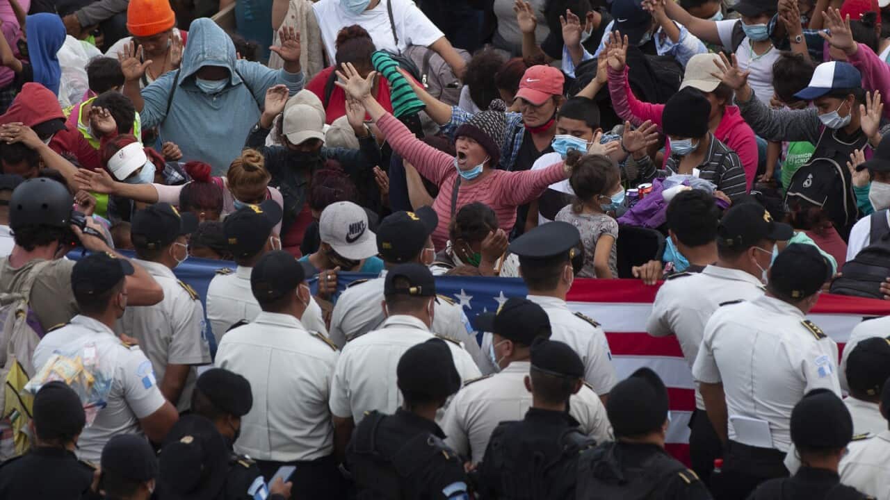 Tear gas and sticks were used to stop a group of Honduran asylum seekers attempting to push through a roadblock.