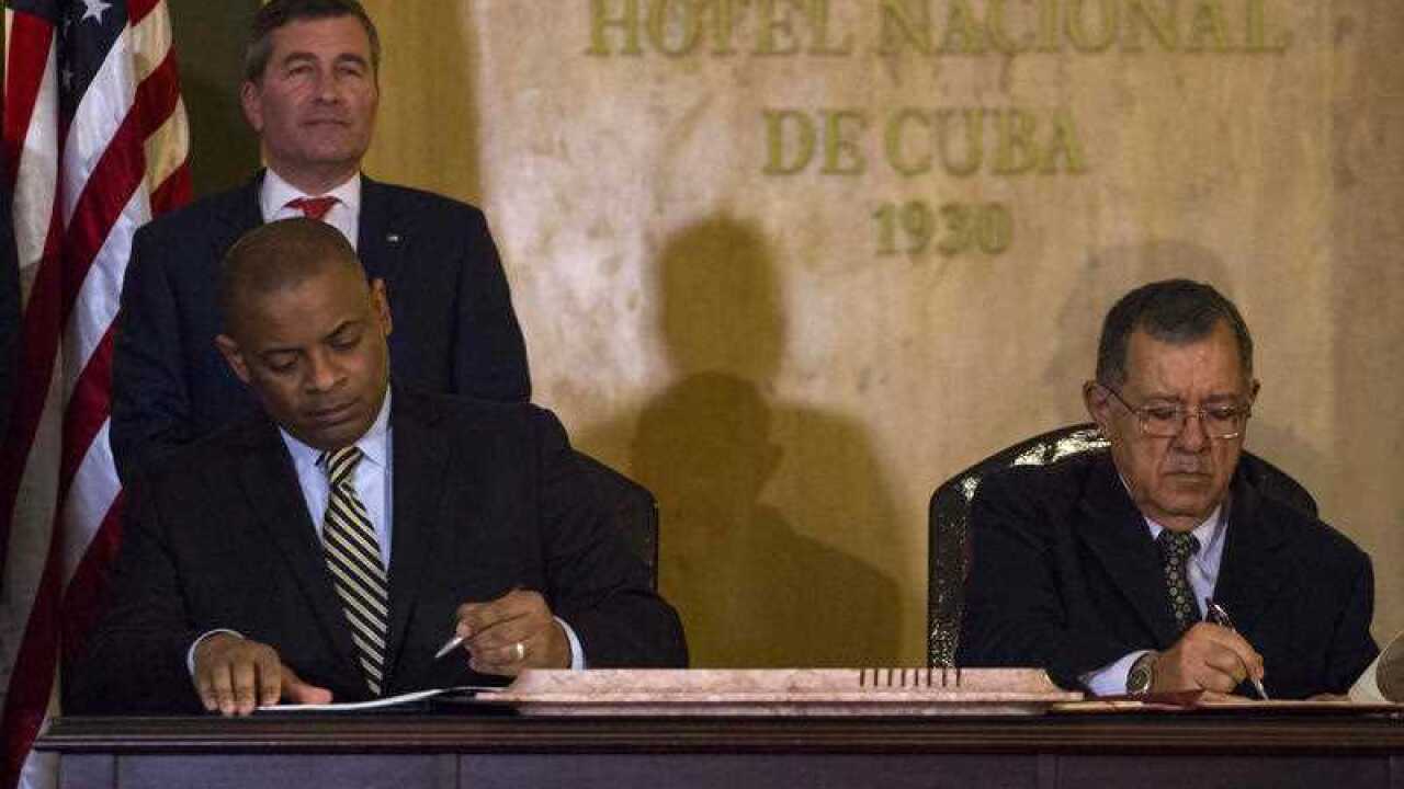 United States Transportation Secretary Anthony Foxx and Cuba's Minister of Transportation Adel Yzquierdo Rodriguez, right, sign the airline transportation agreement.