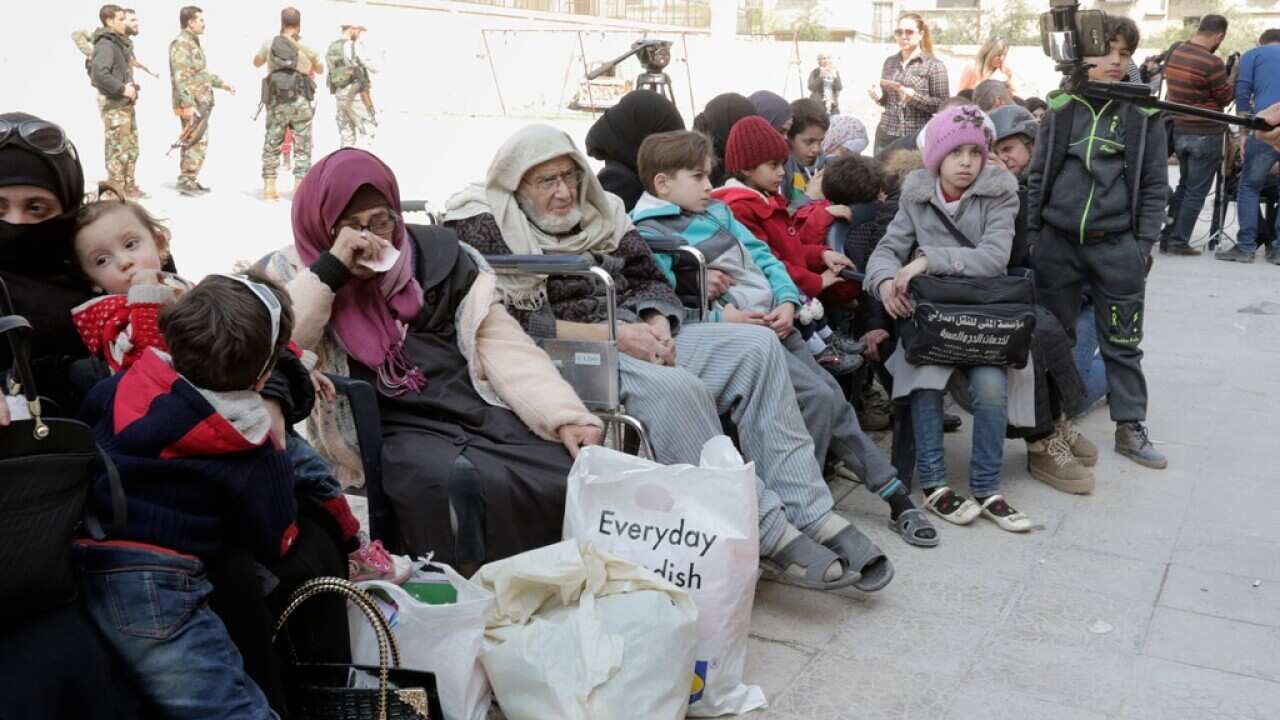 Syrian people from easter Ghouta wait to be evacuated