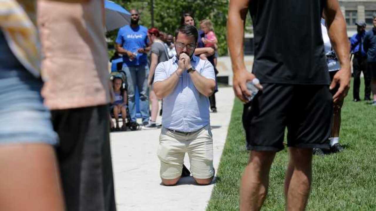 A praying man is among the mourners following the mass shooting in Dayton, Ohio