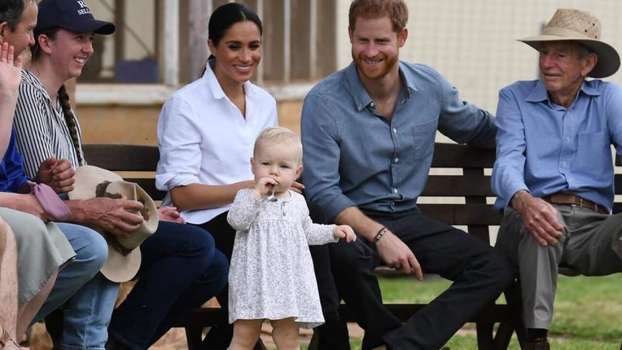 Meghan and Harry smile at toddler Ruby Carroll at a Dubbo farm.
