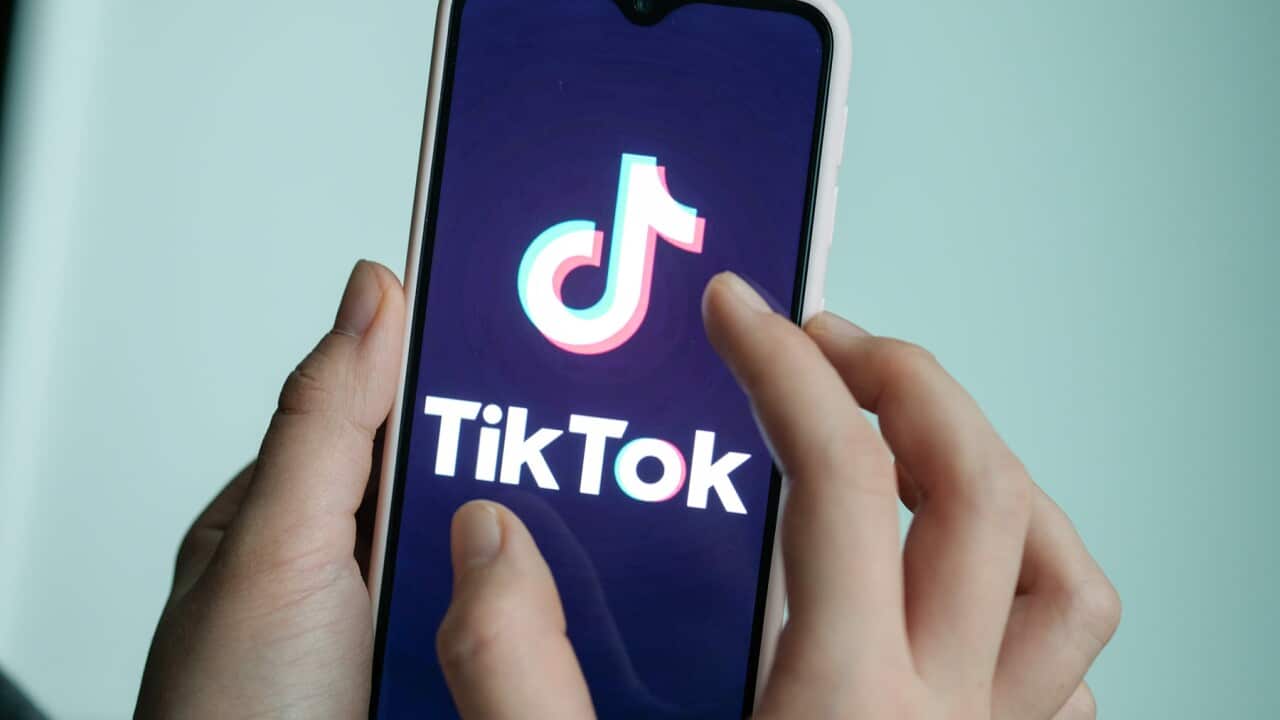 A smartphone with TikTok's logo and a user's hand (AAP).jpg