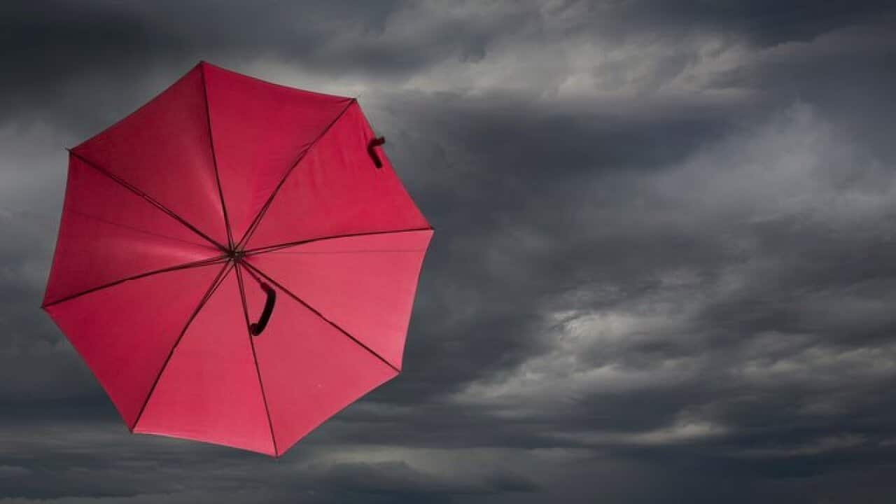 Red umbrella blowing in storm