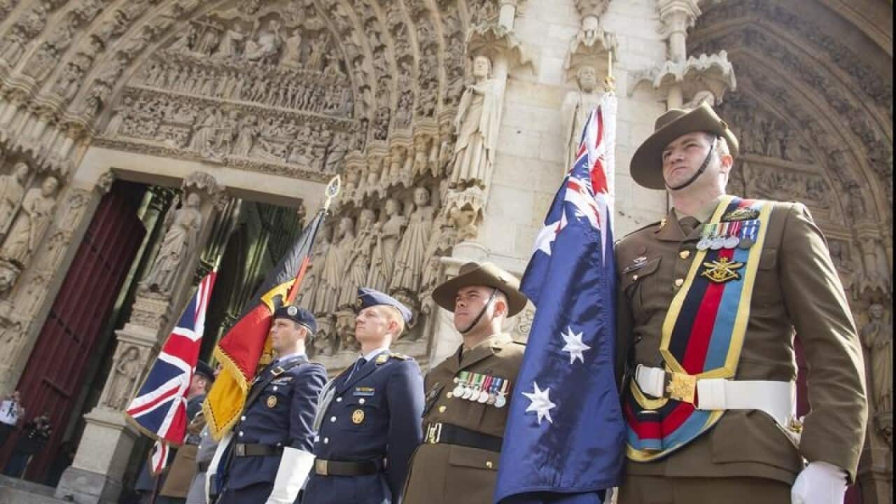 Soldiers carry the flags of the Allies outside Amiens Cathedral