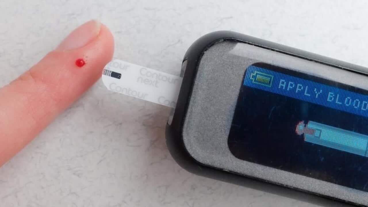 A woman checks her blood sugar with a finger prick test.