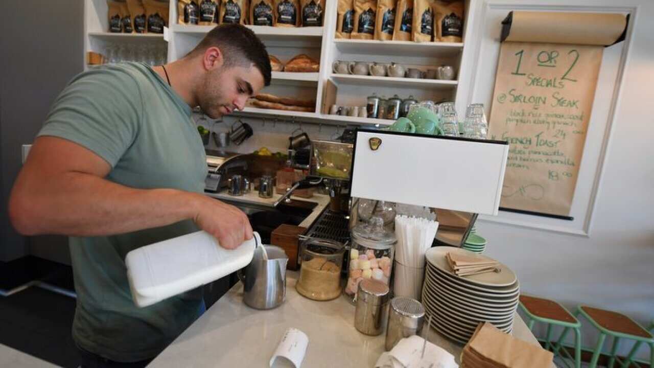 A barista is seen prepairing a coffee at a cafe in Canberra.