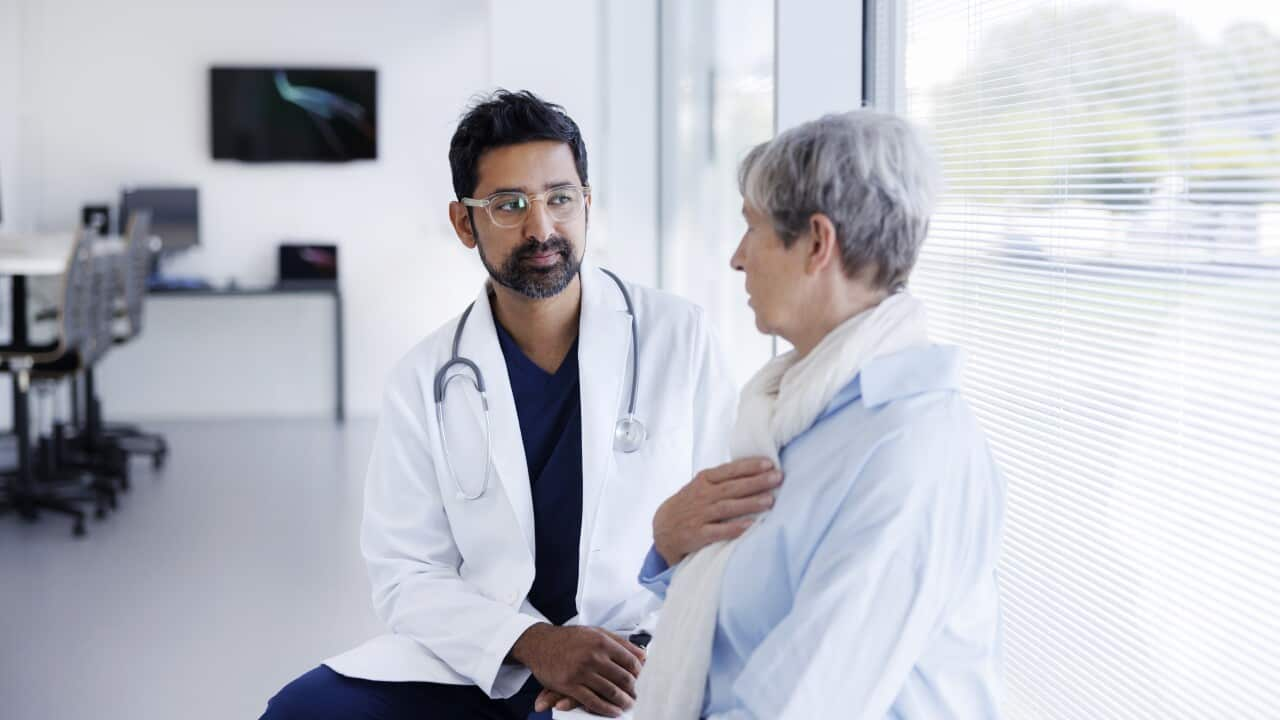 Doctor and patient in conversation in hospital hallway