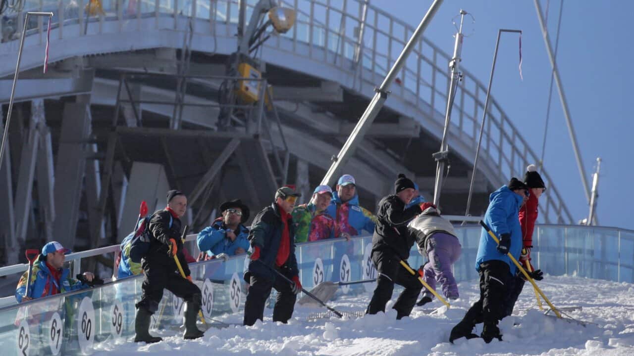 Workers prepare the landing slope of the NH ski jump at the Sochi 2014 Olympic Games, (AAP)