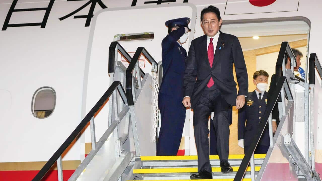 Japanese Prime Minister Fumio Kishida walks down the boarding ramp upon his arrival at an airport in Perth on 21 October 2022.