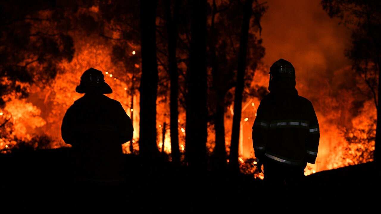 Firefighters watch on as the Gospers Mountain fire approaches a property at Colo Heights, north west of Sydney, Friday, November 15, 2019.
