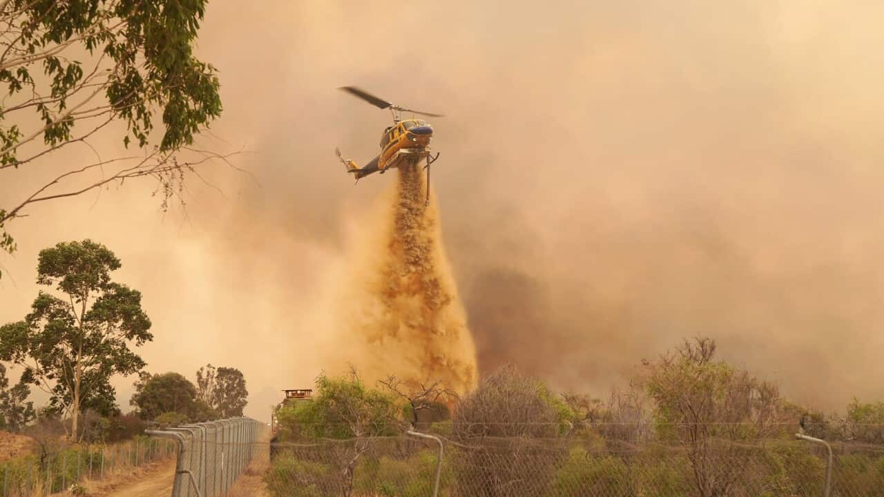 A helicopter drops fire retardant on a fire near Wooroloo (AAP)