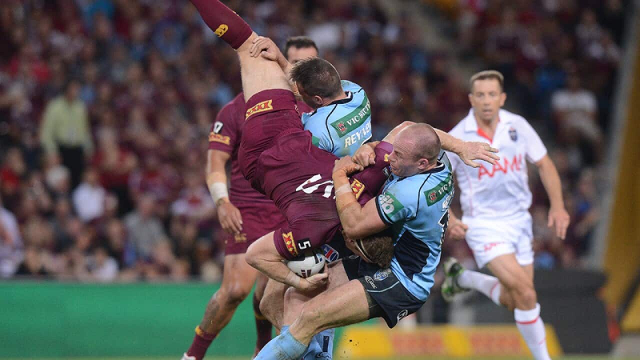 Queensland's Brent Tate is tackled by Josh Reynolds and Beau Scott
