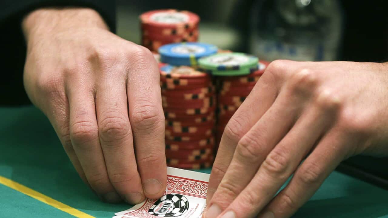 A player checks his hand during a game of Texas Hold 'em