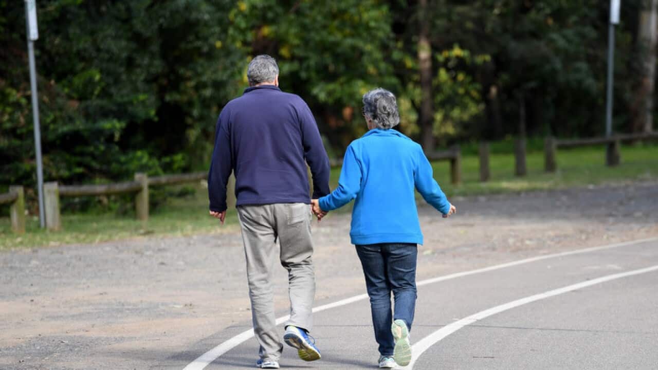 An elderly couple walk through a park in Sydney on Sunday, April 30, 2017. (AAP Image/Paul Miller) NO ARCHIVING