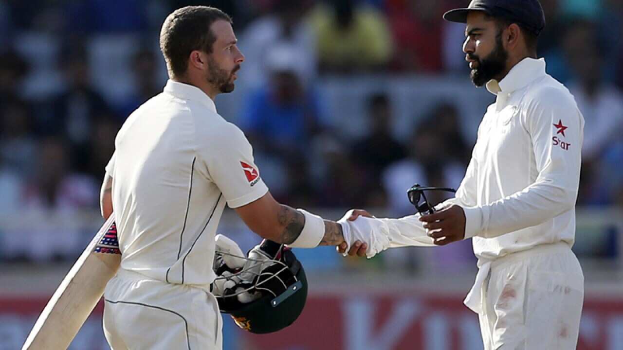 India's Virat Kohli (R) shakes hands with Australia's Matthew Wade