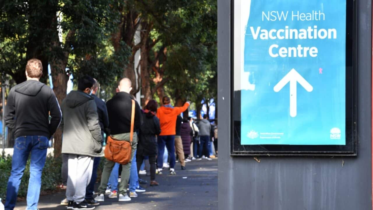 People are seen queued to receive their vaccination at the NSW Vaccine Centre at Homebush Olympic Park in Sydney.