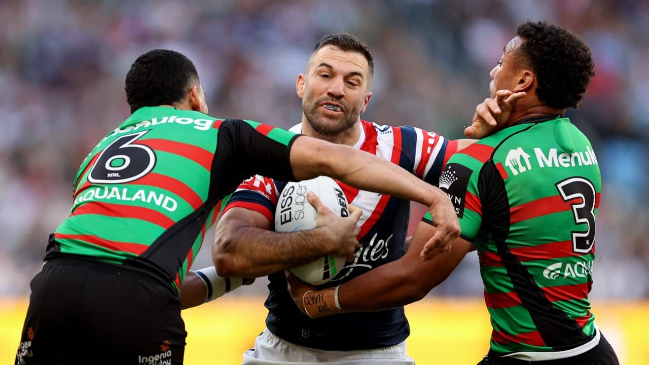 A rugby player is tackled by two others